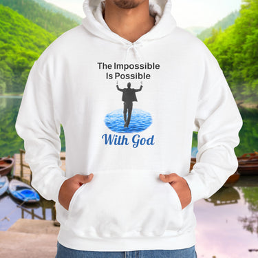 Gildan unisex hoodie with “Impossible Man” design featuring a man walking on water and uplifting message, Christian apparel made from soft cotton-poly blend, perfect for cold weather and spiritual encouragement, man in white hoodie
